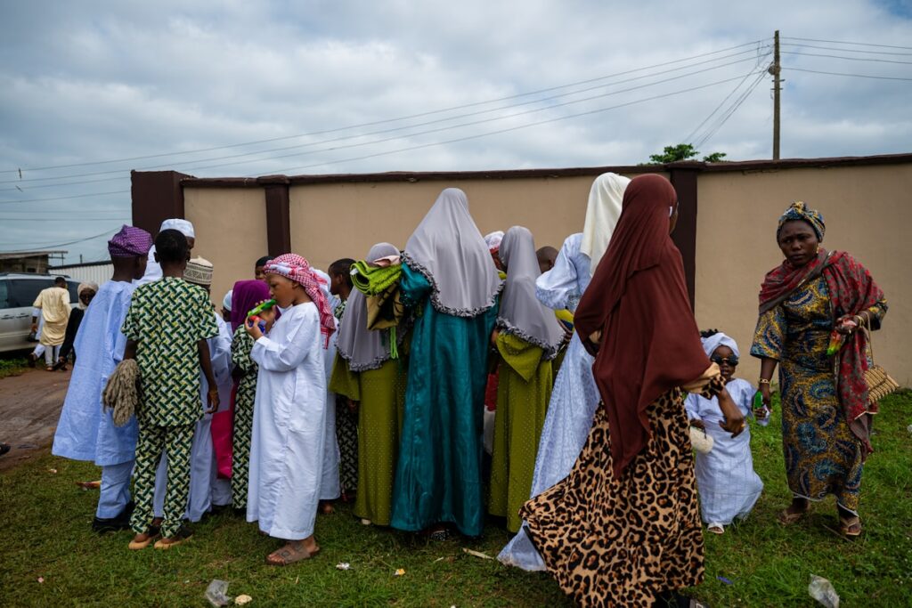 Mulheres e crianças africanas reunidas ao ar livre, representando as comunidades cristãs vulneráveis da Nigéria