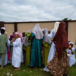 Mulheres e crianças africanas reunidas ao ar livre, representando as comunidades cristãs vulneráveis da Nigéria