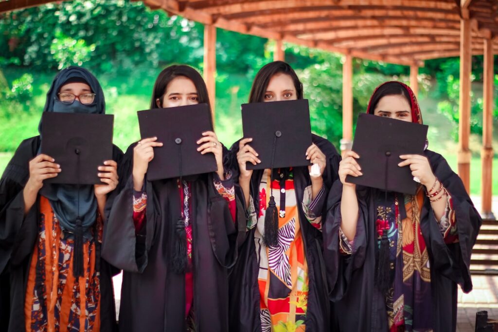 a group of women holding up black paper