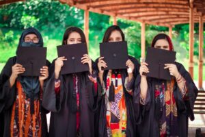 a group of women holding up black paper