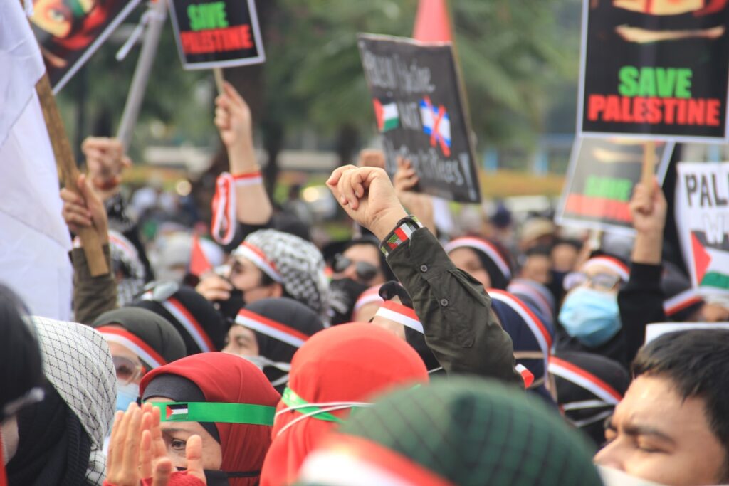 Grande grupo de pessoas segurando cartazes em protesto