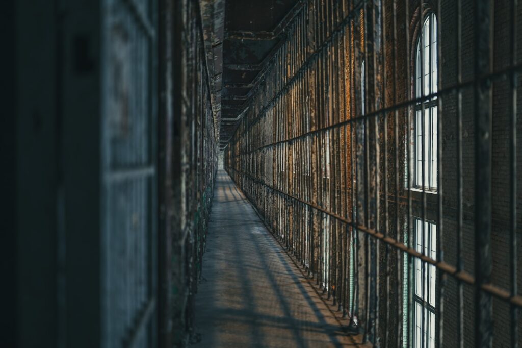 Corredor de prisão com celas gradeadas representando perseguição a cristãos na Rússia