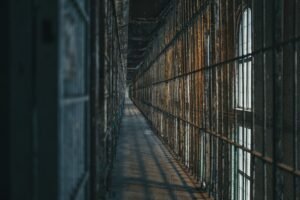 Corredor de prisão com celas gradeadas representando perseguição a cristãos na Rússia